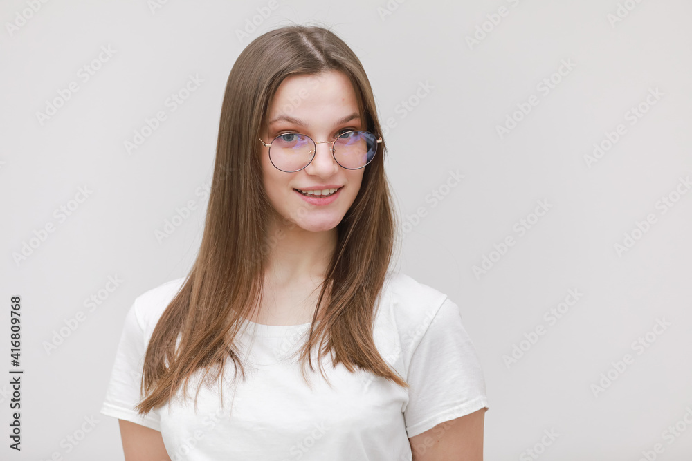 Happy cute millennial teen girl student in glasses looking at camera, smiling pretty young woman model in eyewear posing isolated on white background, head shot portrait