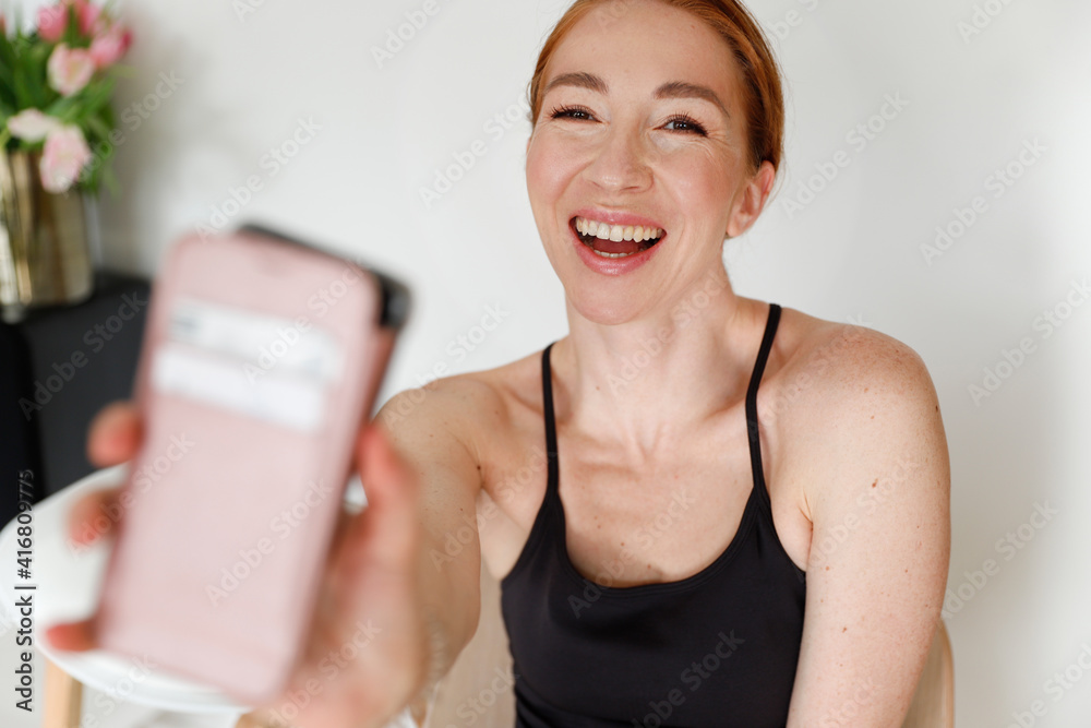 Young woman is doing selfie. She is smiling and happy. WOman holding a smartphone Young woman is doing selfie. She is smiling and happy. WOman holding a smartphone