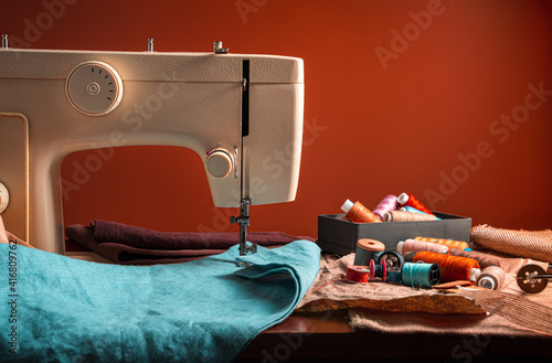 Sewing machine and sewing accessories on a brown background.