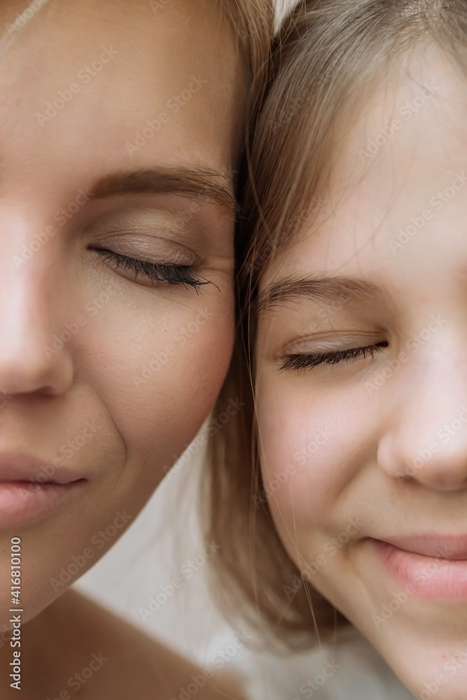two halves of the face of a mother and daughter in close-up. the concept of maternal love and care, happy motherhood two halves of the face of a mother and daughter in close-up. the concept of maternal love and care, happy motherhood