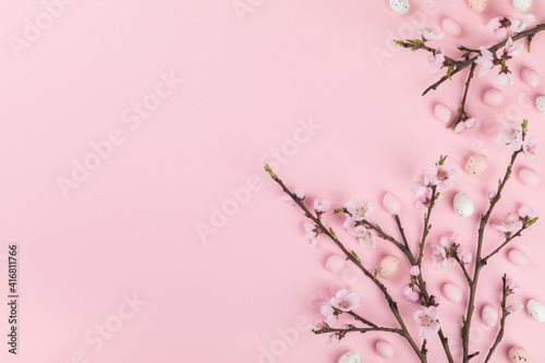 Easter composition painted eggs flowering cherry branchon a pink background.