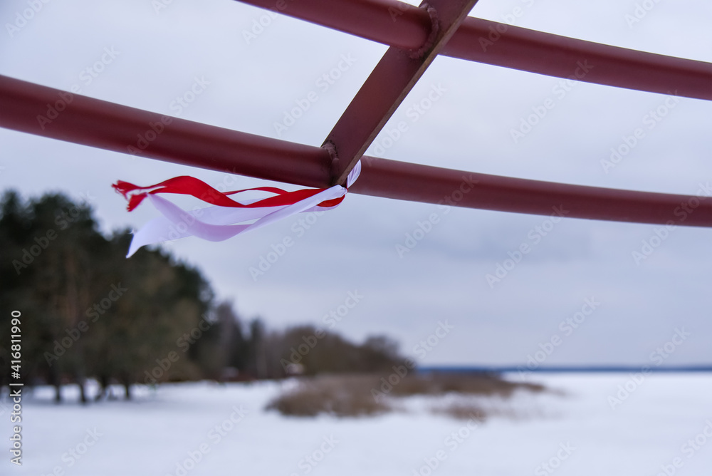 Red and white ribbons flutter in the wind in winter