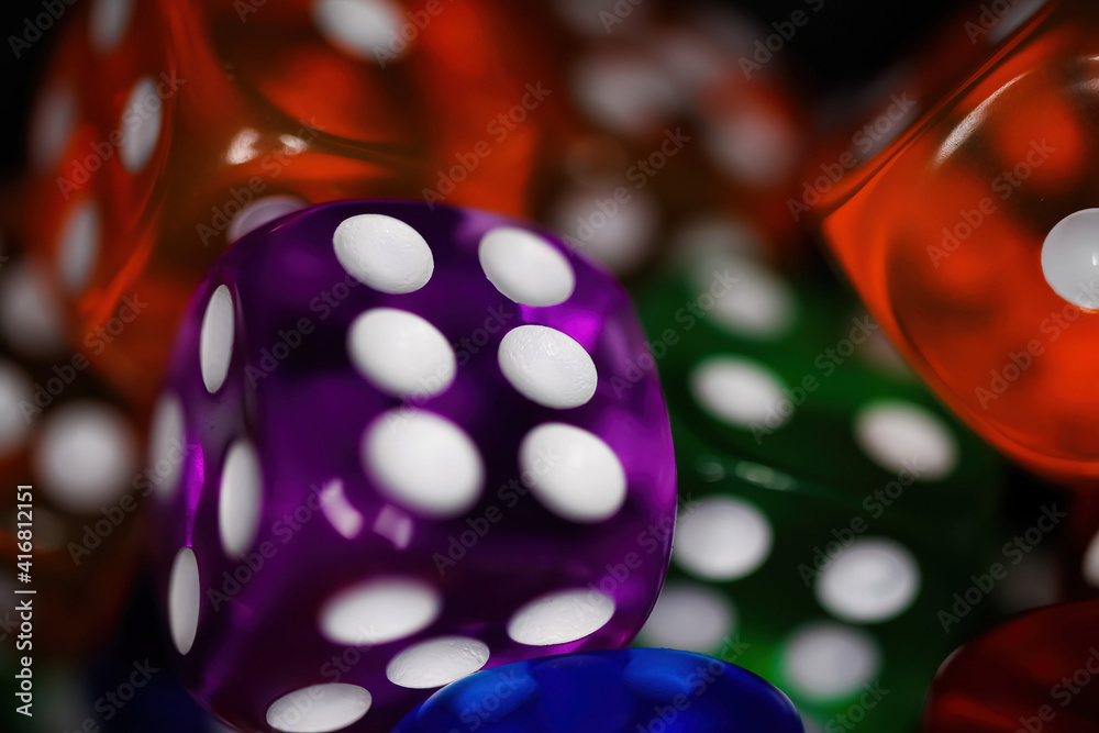 Makro closeup of multi colored blurred isolated  shiny glowing illuminated mixed up dices