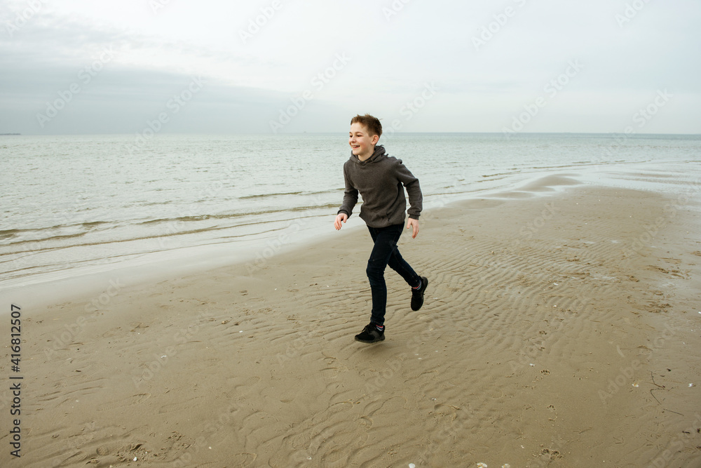 Portrait of handsome teenager child boy walking and posing on Baltic sea beach Portrait of handsome teenager child boy walking and posing on Baltic sea beach