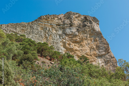 Scenic view of rock and green junipers on a hot summer day, near Sudak, Crimea. © Ann