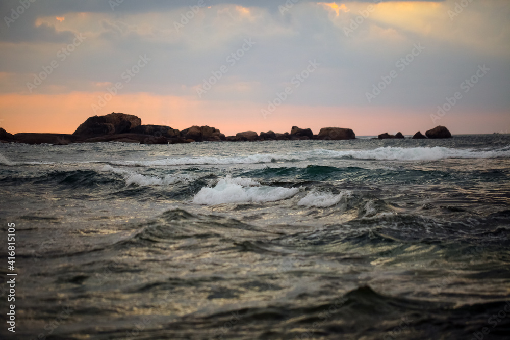splashing ocean waves in the evening. rocks in the water splashing ocean waves in the evening. rocks in the water