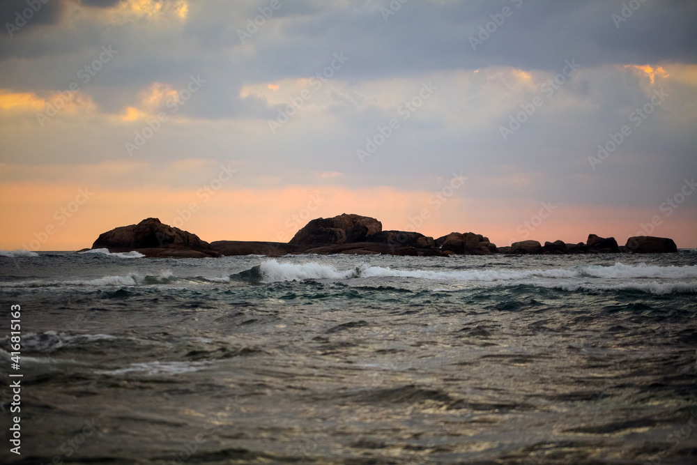 splashing ocean waves in the evening. rocks in the water