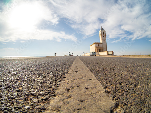 Coastal road and church of San Miguel in Almadraba de Monteleva, Cabo de Gata Nijar Natural Park, Andalusia Spain.