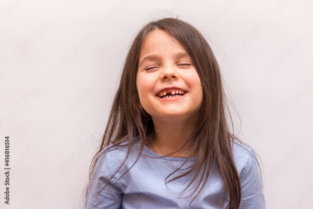 Smiling hispanic little girl with no front tooth on white studio background Smiling hispanic little girl with no front tooth on white studio background