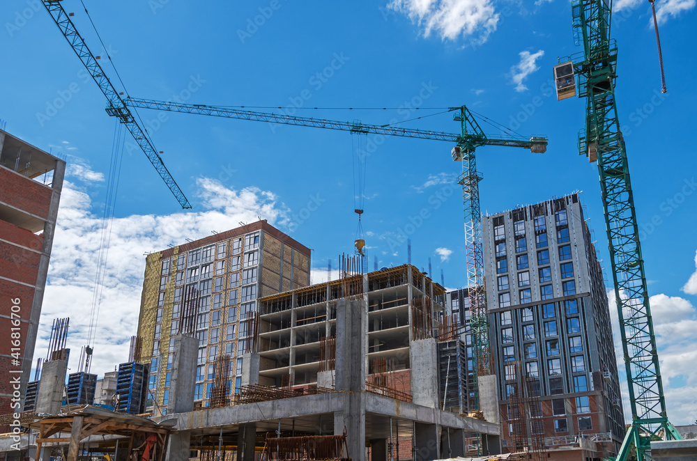 Fototapeta premium Three construction cranes