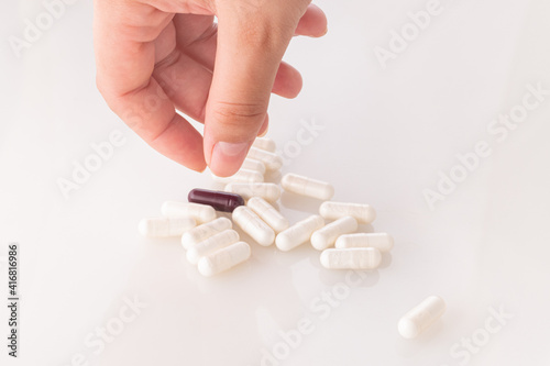 Hand hold pills on white background.