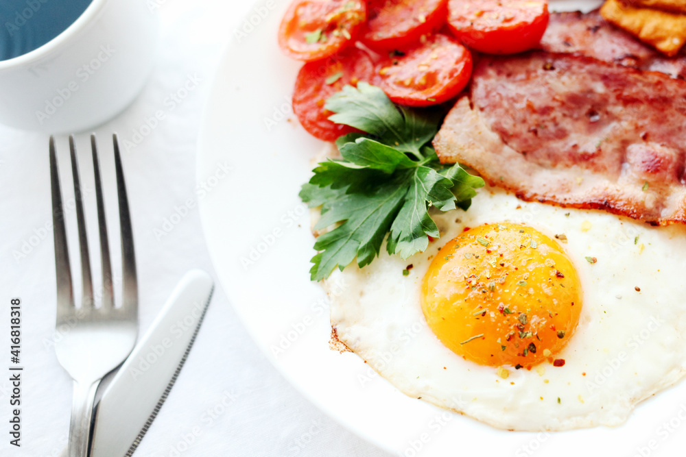 English breakfast - fried eggs, herbs, tomatoes, bacon and crackers English breakfast - fried eggs, herbs, tomatoes, bacon and crackers