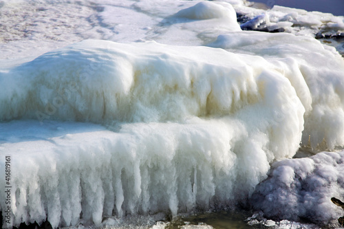 Ice covered rocky coast of the Baltic Sea on wintertime in Latvia. White snow, ice covers the land on seaside.