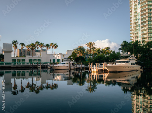 horizontal landscape beautiful blue sky white clouds reflections water house building boat marina florida palms trees reflections sun