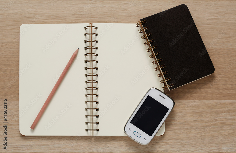 Blank Spiral Note Pad, computer mouse, cellphone and Pencil on Wood Background. Blank Spiral Note Pad, computer mouse, cellphone and Pencil on Wood Background.