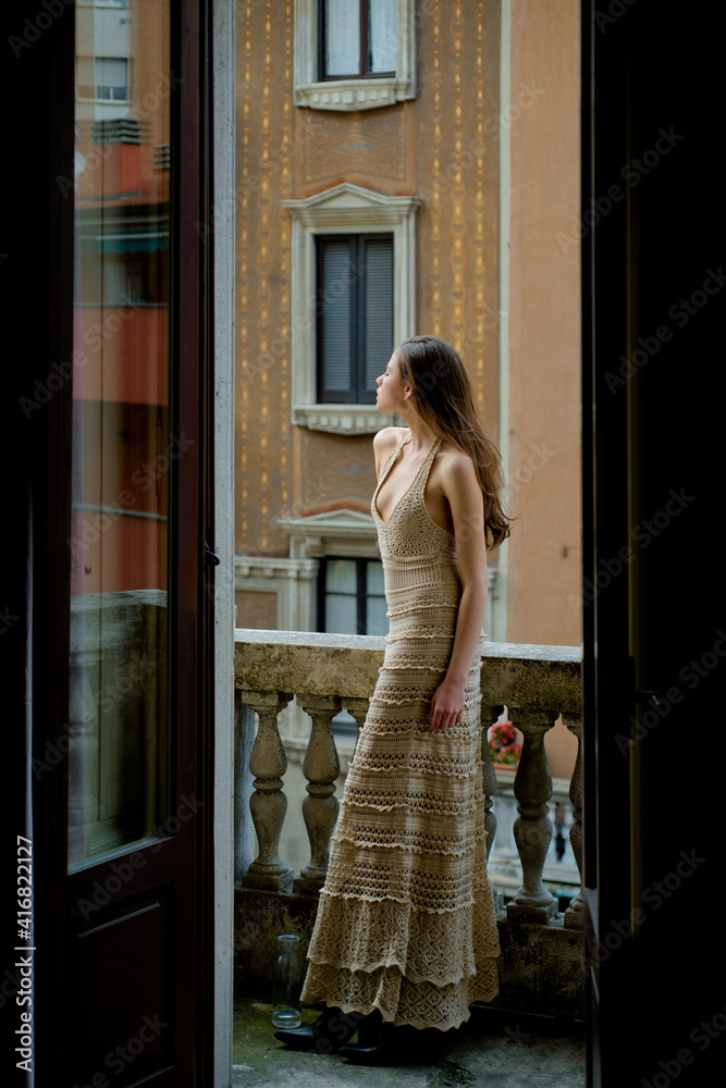 Woman on balcony. City girl portrait. Fashion and beauty. Luxury street style.