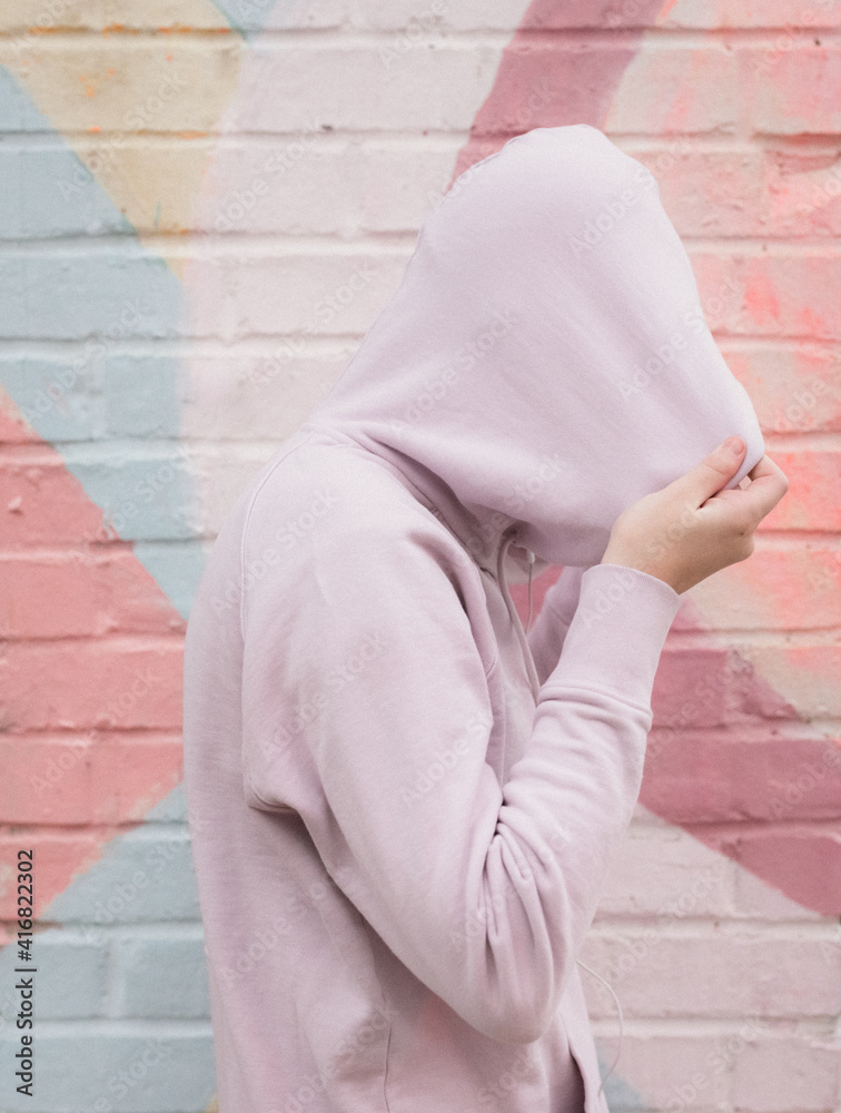 Shy Introverted Teen Pulls Hoodie over head for mental health and bullying awareness Shy Introverted Teen Pulls Hoodie over head for mental health and bullying awareness