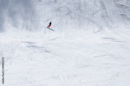Beautiful texture created by skiers descending the mountain. Sportsman descends along the snowy slope of a ski resort .The concept of winter sports. High quality photo