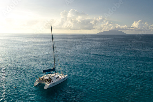 Canvas Print Eco yacht catamaran sailing in ocean at sunset. Aerial view