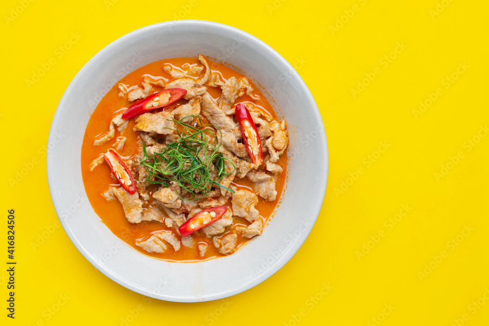 Panaeng Curry with pork in white bowl on yellow background. Panaeng Curry with pork in white bowl on yellow background.