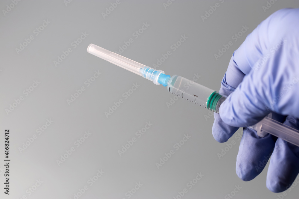 Doctor's hands are holding a syringe filled with vaccine. Prevention, immunization and treatment for coronavirus infection COVID-19, nCoV 2019. COVID19 vaccine concept. Copy space Doctor's hands are holding a syringe filled with vaccine. Prevention, immunization and treatment for coronavirus infection COVID-19, nCoV 2019. COVID19 vaccine concept. Copy space