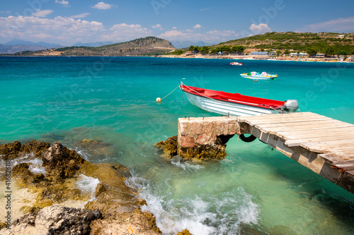 wooden pier and boat in Ksamili paradise beach in Albania