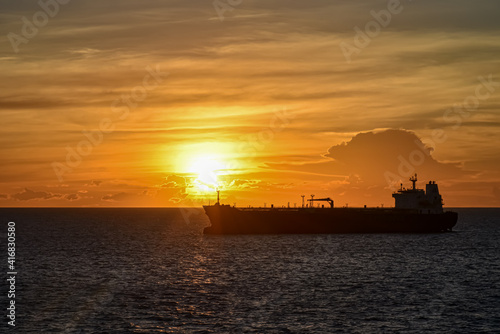 Silhouette of the cargo ship on a beautiful sunset background. © Mariusz