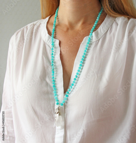 Rosary mala 108 beads from natural stones mint amazonite are worn on a girl in a white shirt. Author's jewelry from natural stones, Buddhism, matra, prayer, rosary from stones for prayer and beauty