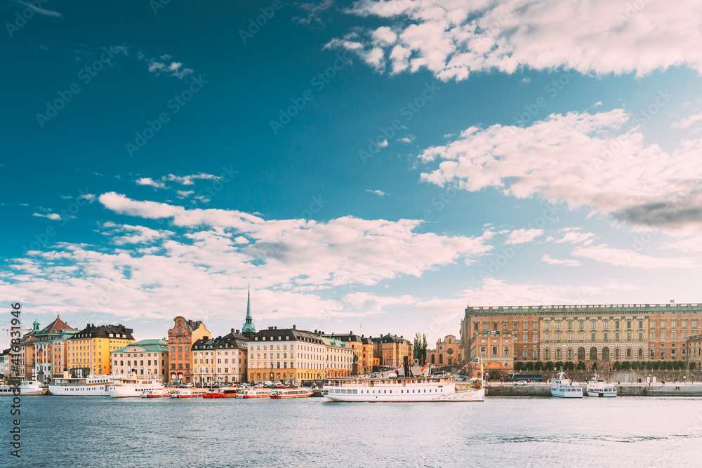 Fototapeta premium Stockholm, Sweden. Touristic Boat Floating Near Famous Embankment In Old Town Gamla Stan In Summer Evening. Famous Popular Destination Scenic Place And UNESCO World Heritage Site