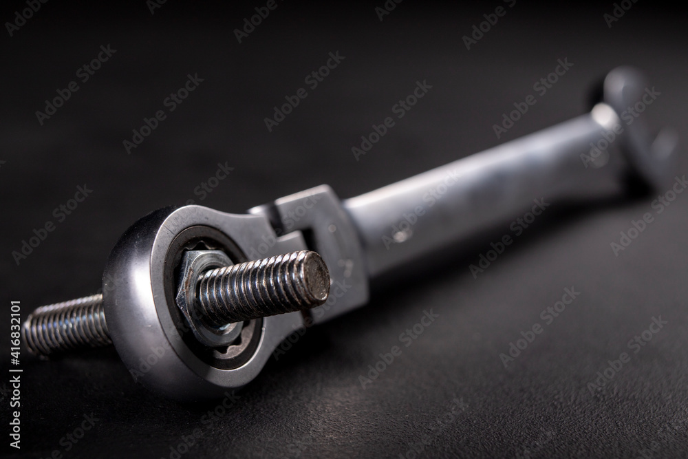 Fototapeta premium A screw and a metal wrench in the workshop. Accessories for mounting metal elements. Dark background. 