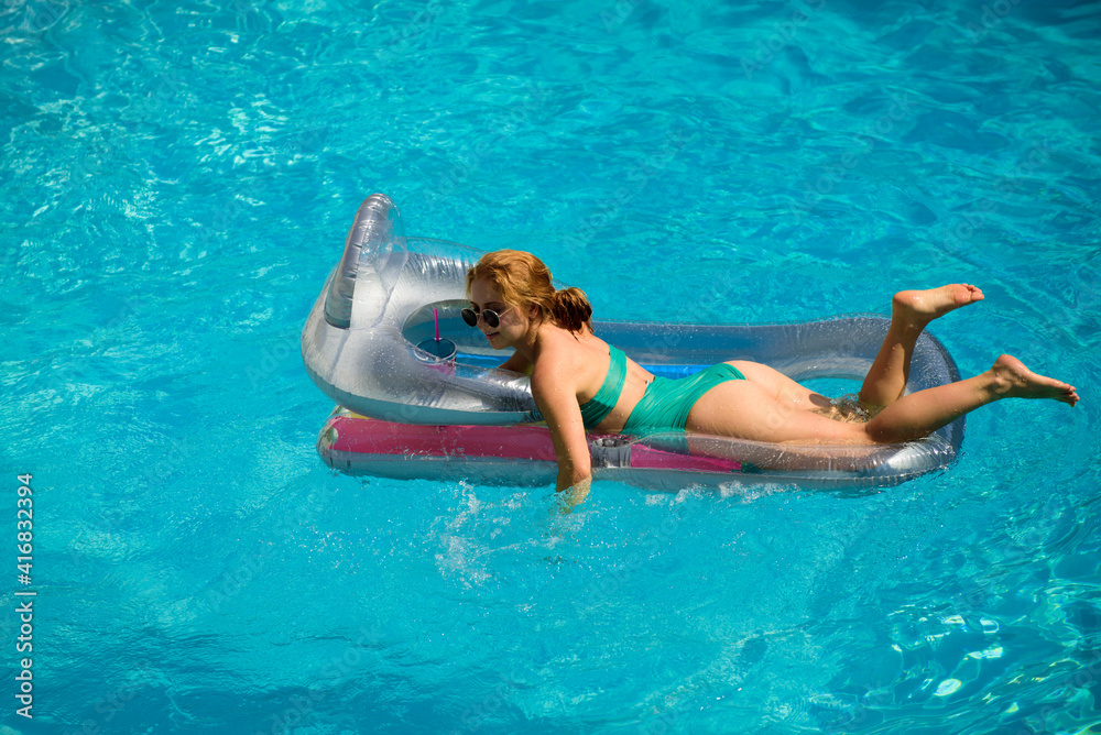 Woman in swimmsuit on summer vacation. Girl swimming pool. Summer lady on inflatable mattress.