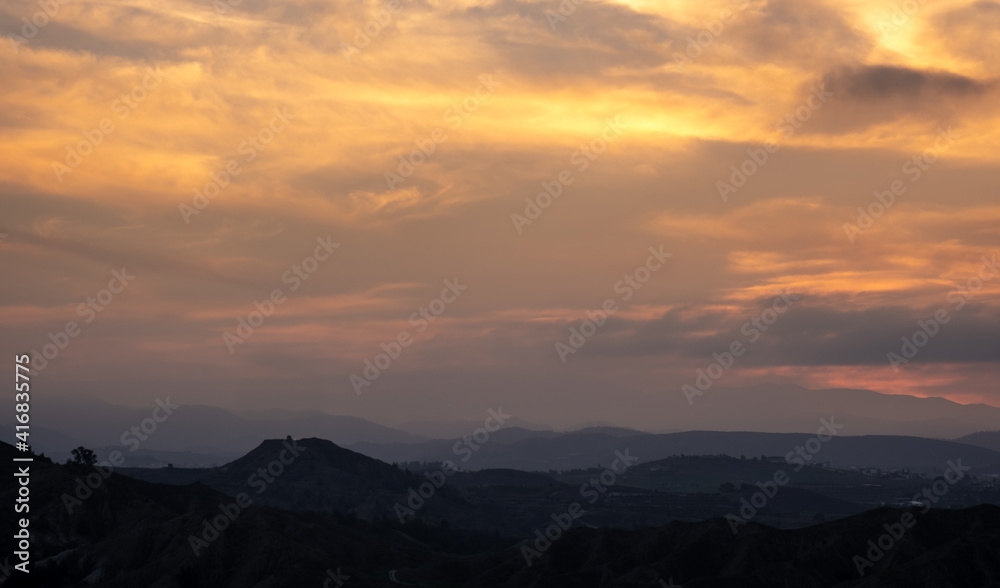 Panoramic mountain landscape with cloudy sky at sunset