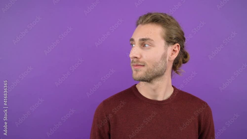 smiling contented man on isolated purple background looking left at his own space 4K smiling contented man on isolated purple background looking left at his own space 4K