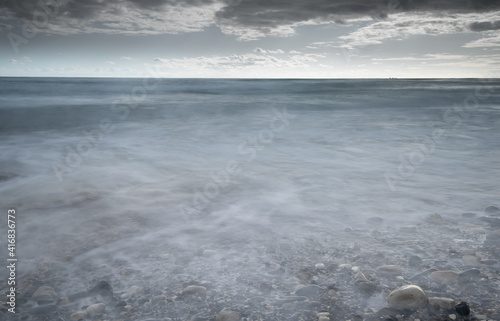 Seawaves splashing to the coast with stones against stormy dramatic cloudy sky. Wintertime, Limassol cyprus photo