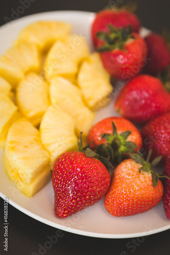 Close-up of sliced melon and berries. Strawberries and melons are on a white plate. Diet fruit salad - breakfast  weight loss concept. Healthy snack.