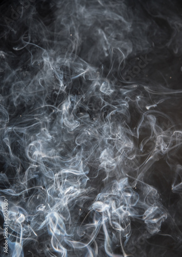 Abstract puffs of smoke on a black background.