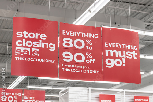 Store Closing and huge discount signs displayed at a soon to be out of business clearance sale. Everything must go at up to 90 percent off sale. photo