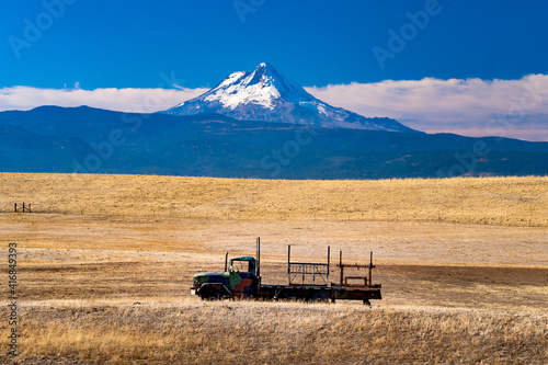 A farm truch in a dry pasture on a farm near Dufur Oregon, with Mt Hood in the background.