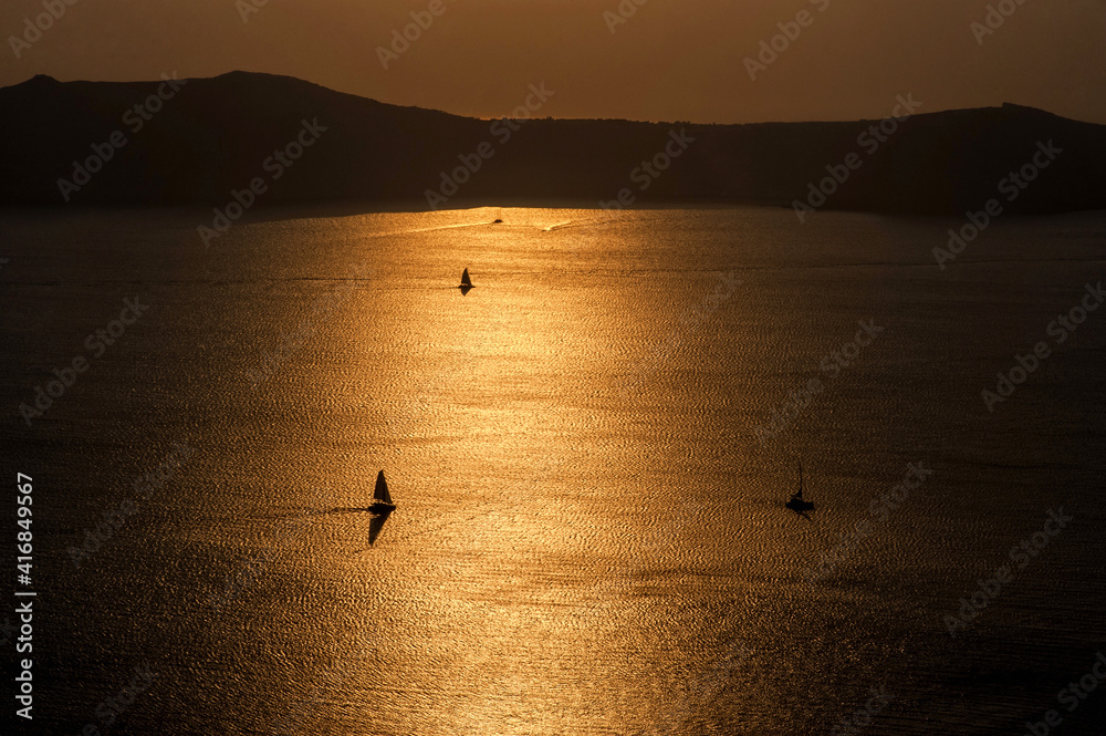 Silhouettes sailboats sailing in Santorini, Greece.