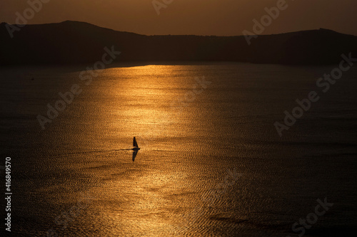Silhouettes sailboats sailing in Santorini, Greece.