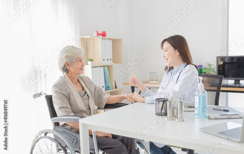 old Asian patient talk with female doctor, asian doctor show thumb up sign with hand together, elderly health check up, happiness hospital