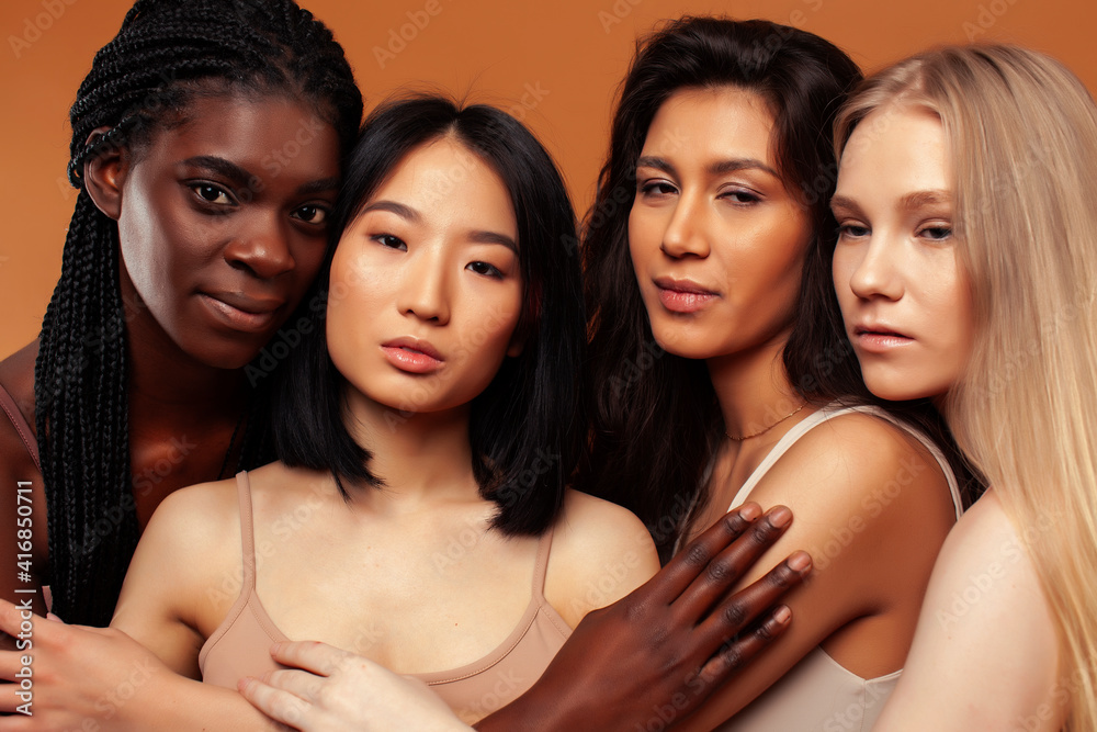 Obraz premium young pretty asian, caucasian, afro woman posing cheerful together on brown background, lifestyle diverse nationality people concept