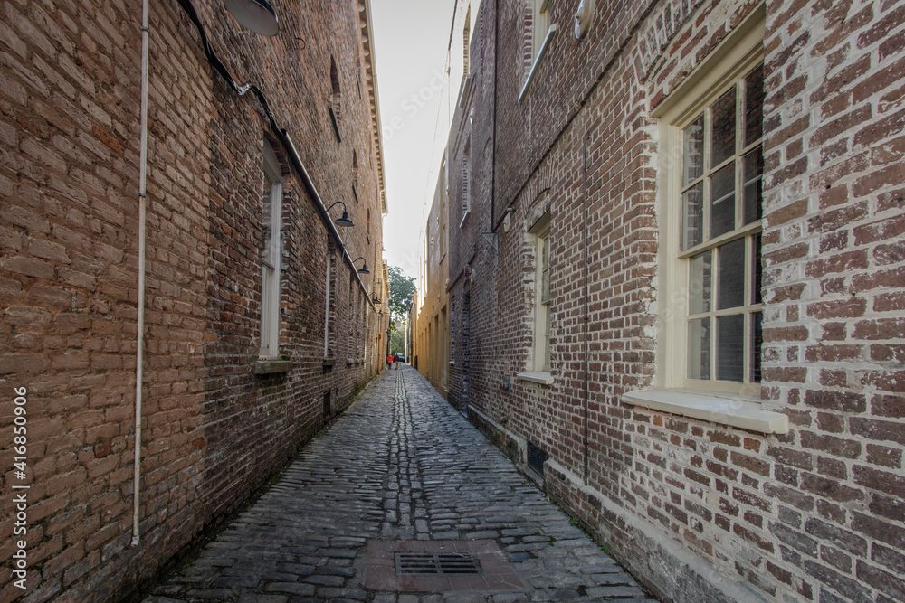 Fototapeta premium Lodge Alley in Charleston, South Carolina is one of city's few remaining cobblestone streets. Charleston is famous for it's hidden and secret alleyways and this one dates back to the early 1700s.