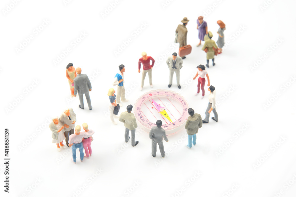 miniature people. different people are standing near the compass. finding direction in life miniature people. different people are standing near the compass. finding direction in life