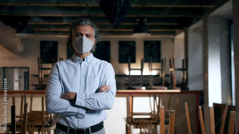 Frustrated owner looking at camera in closed cafe, small business lockdown due to coronavirus. Frustrated owner looking at camera in closed cafe, small business lockdown due to coronavirus.