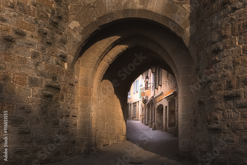 A quaint passageway underneath arches in the city walls of the fortified old town medieval citadel of Carcassonne, France.