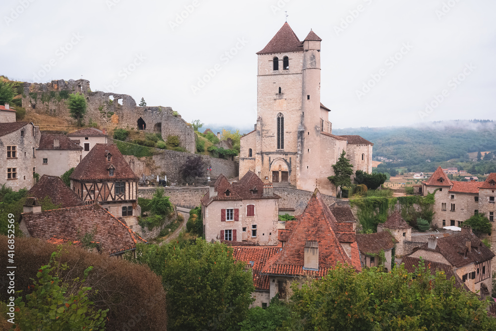 The French medieval hilltop village of Saint-Cirq-Lapopie and its 16th century fortified church in the Lot Valley, France.