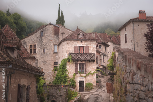 The quaint and charming French medieval hilltop village of Saint-Cirq-Lapopie on a foggy  misty morning in the Lot Valley  France.