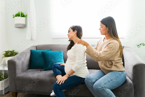 Midwife relieving the shoulder and back pain of a pregnant woman