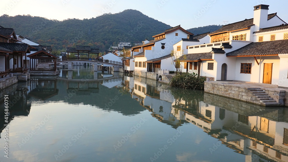 Retro buildings on both sides of the river and bridge's reflection in the water, China's Water Village